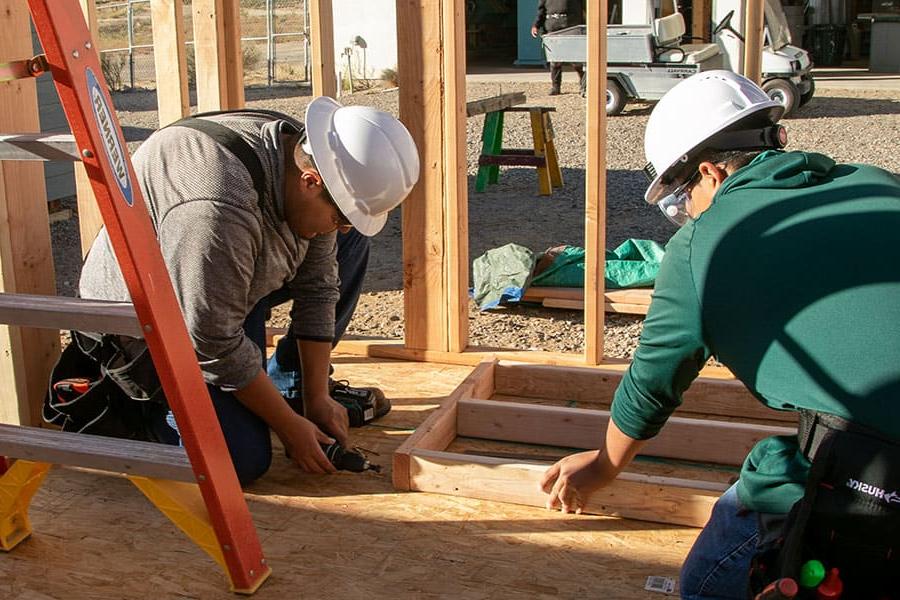 Two 太阳集团娱乐场登陆网站 students working on framing a building